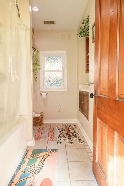 bathroom featuring tile patterned flooring, vanity, and shower / tub combo