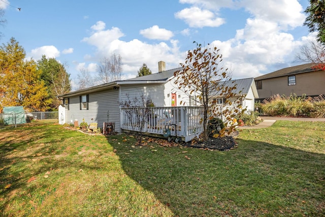 view of side of home featuring a wooden deck and a yard