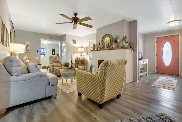 living room with hardwood / wood-style floors, a fireplace, and ceiling fan