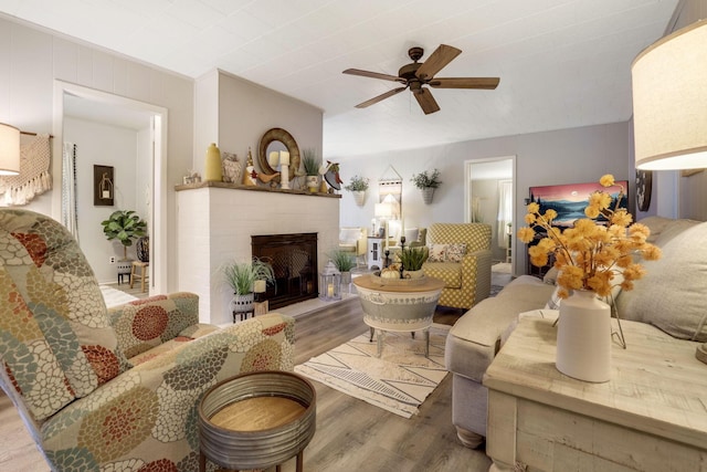 living room with ceiling fan, hardwood / wood-style floors, and a fireplace