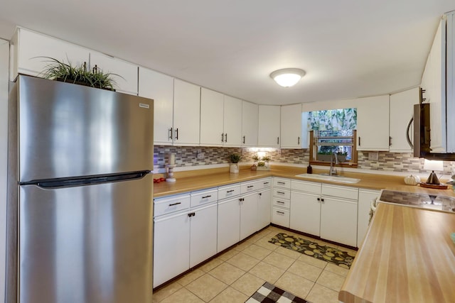 kitchen with white cabinetry, appliances with stainless steel finishes, sink, and backsplash