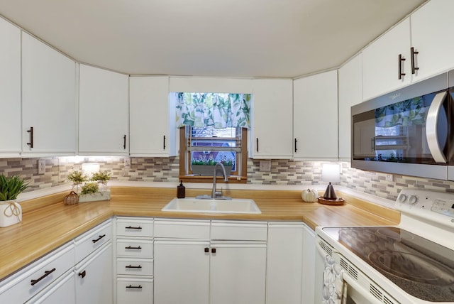 kitchen featuring white electric stove, white cabinetry, sink, and decorative backsplash