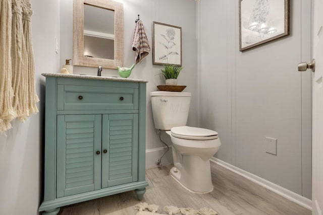 bathroom with vanity, toilet, and wood-type flooring