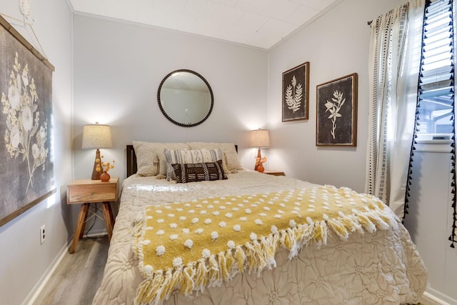 bedroom with crown molding and light wood-type flooring