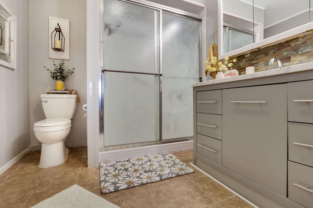 bathroom with vanity, tile patterned flooring, a shower with door, and toilet