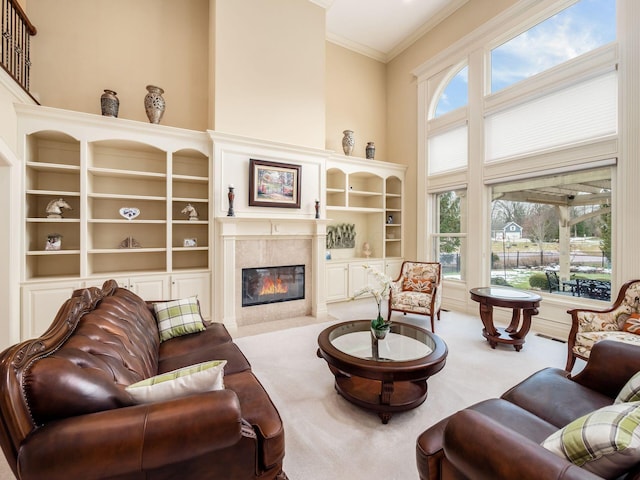 living room featuring a high ceiling, crown molding, light carpet, and a fireplace