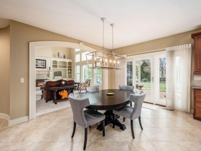 tiled dining room with lofted ceiling and a chandelier