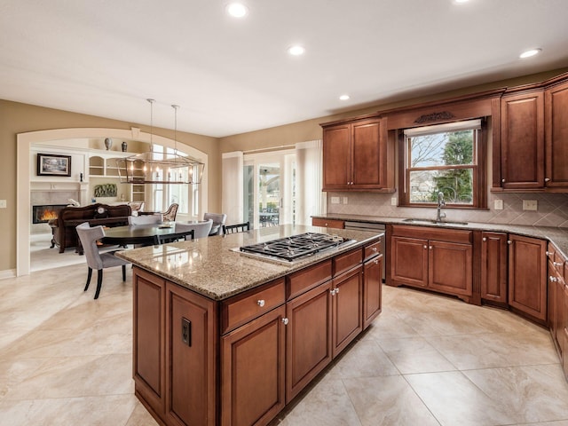 kitchen with a healthy amount of sunlight, stainless steel gas stovetop, decorative light fixtures, and sink