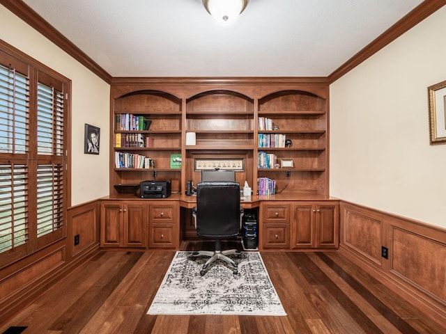 office space with ornamental molding, dark wood-type flooring, built in desk, and built in shelves