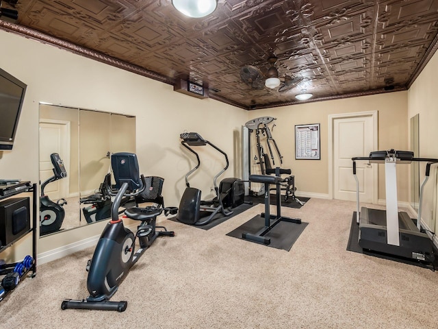 workout area featuring ornamental molding and carpet floors