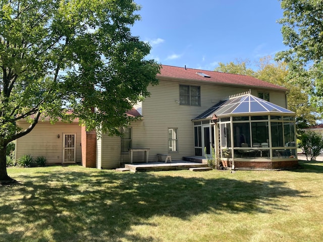 rear view of property with a lawn and a sunroom