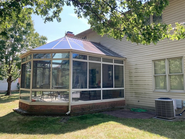 rear view of house with a yard, a sunroom, a patio area, and central air condition unit