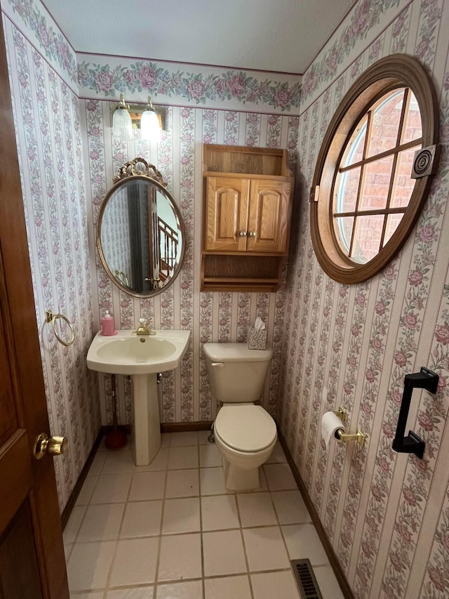 bathroom with toilet, tile patterned floors, and sink