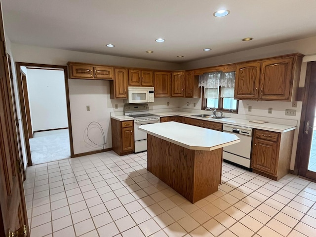 kitchen with light tile patterned floors, white appliances, a kitchen island, and sink