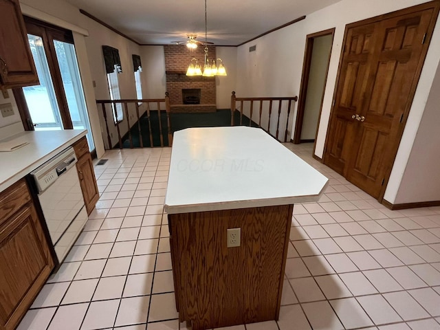 kitchen with a fireplace, ornamental molding, decorative light fixtures, dishwasher, and a center island