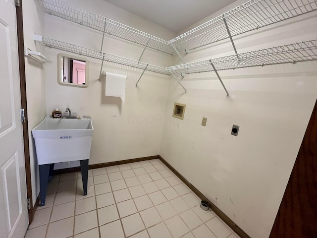 clothes washing area with hookup for an electric dryer, washer hookup, and light tile patterned floors