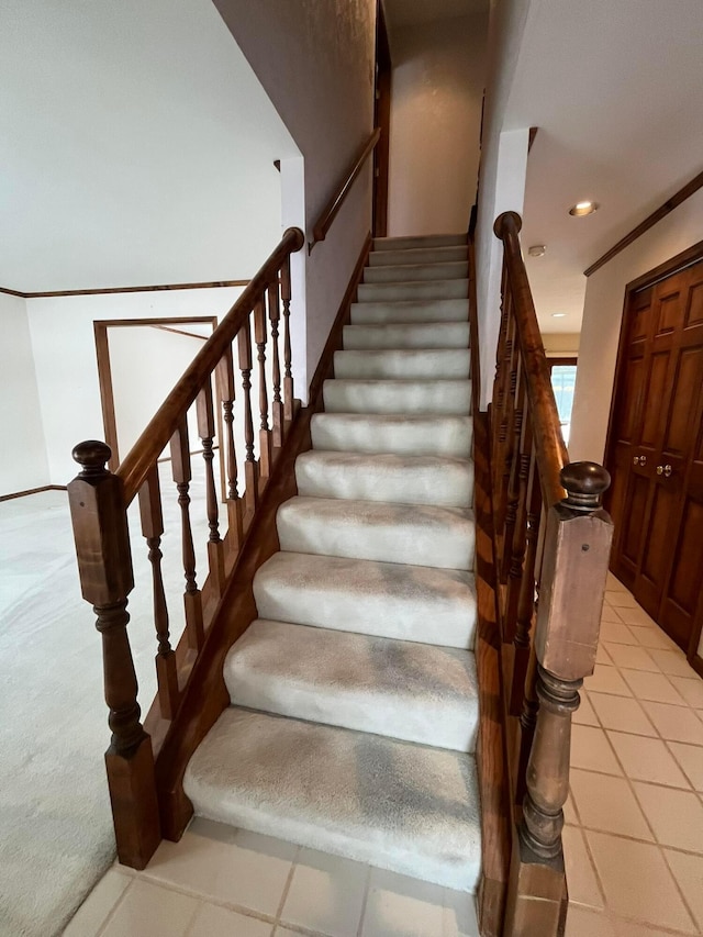 stairs featuring carpet floors and ornamental molding