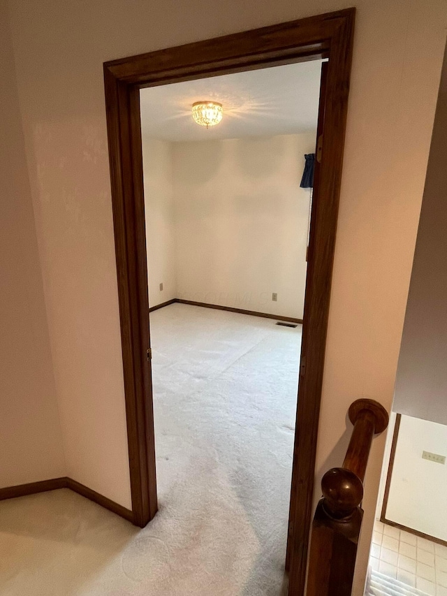 hallway featuring light colored carpet