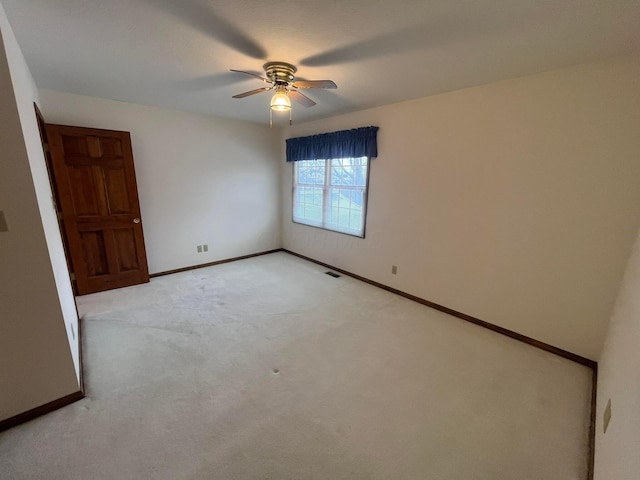 carpeted spare room featuring ceiling fan