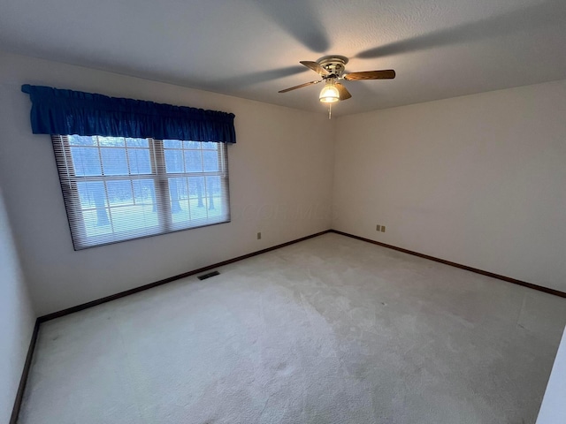 carpeted spare room featuring ceiling fan