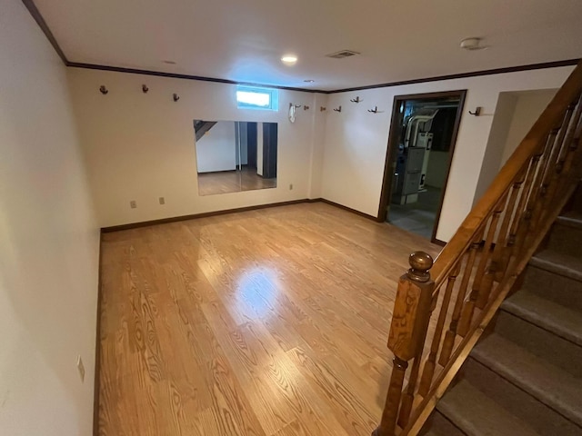 spare room with light hardwood / wood-style flooring and crown molding