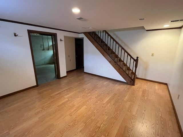 interior space featuring light wood-type flooring and crown molding