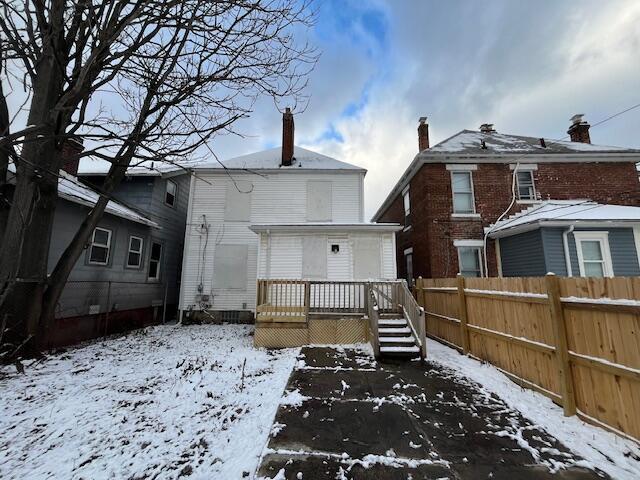 snow covered property with a deck