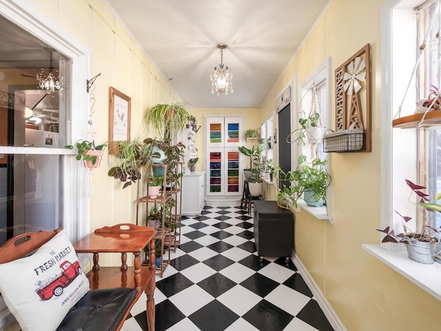 hall with an inviting chandelier and ornamental molding