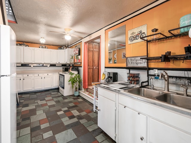 kitchen featuring ceiling fan, white appliances, a textured ceiling, white cabinets, and sink