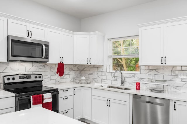 kitchen featuring white cabinets, decorative backsplash, sink, and stainless steel appliances