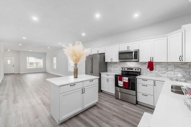 kitchen featuring tasteful backsplash, white cabinetry, and stainless steel appliances