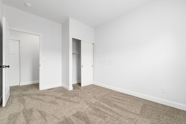 unfurnished bedroom with carpet floors and a closet