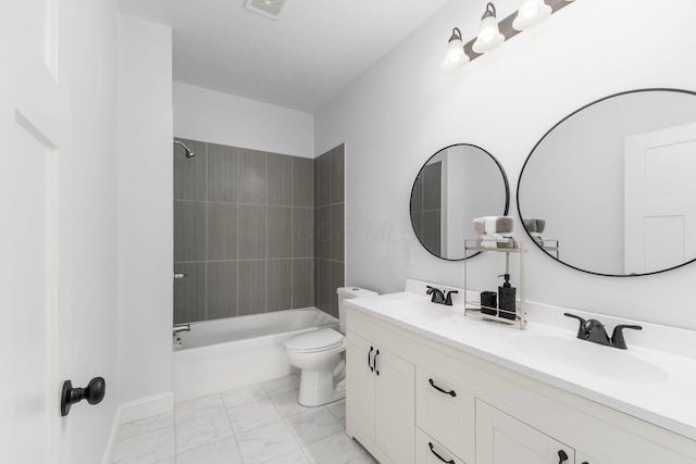 full bathroom featuring vanity, tiled shower / bath combo, and toilet