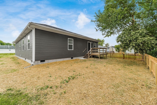 back of property with a lawn and a wooden deck