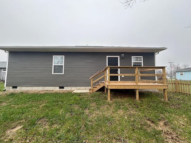 rear view of property featuring a lawn and a wooden deck