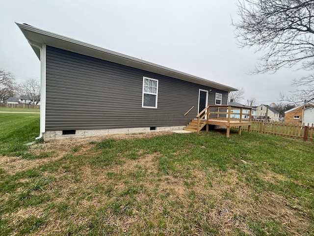 rear view of house featuring a yard and a wooden deck