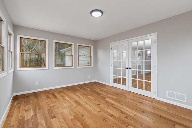 spare room featuring light hardwood / wood-style flooring and french doors