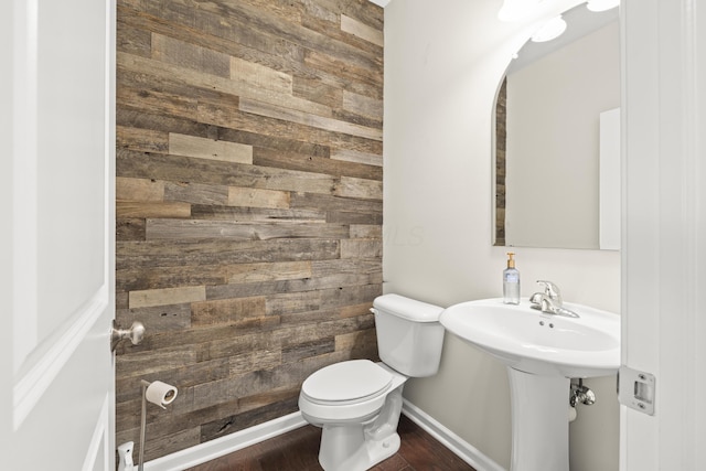 bathroom featuring hardwood / wood-style floors, toilet, and wood walls