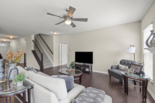 living room featuring a textured ceiling, ceiling fan, and dark wood-type flooring