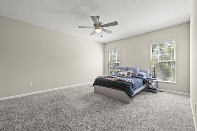 carpeted bedroom with ceiling fan, a textured ceiling, and multiple windows