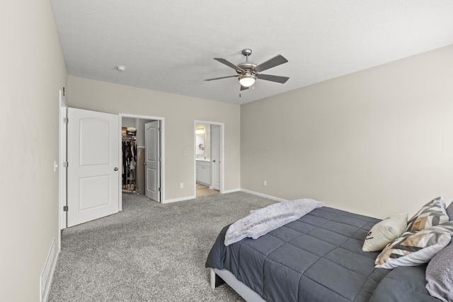 bedroom with light carpet, a walk in closet, ensuite bathroom, ceiling fan, and a closet