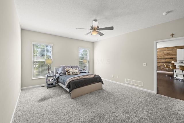 bedroom with carpet flooring, ceiling fan, and a textured ceiling