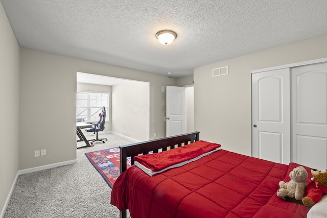 bedroom featuring carpet flooring, a closet, and a textured ceiling