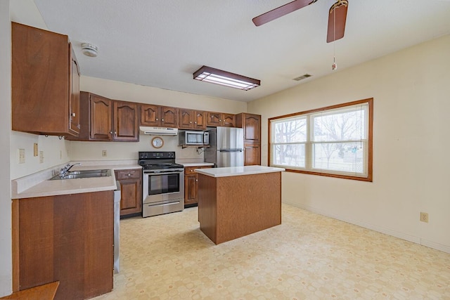 kitchen with a center island, stainless steel appliances, ceiling fan, and sink