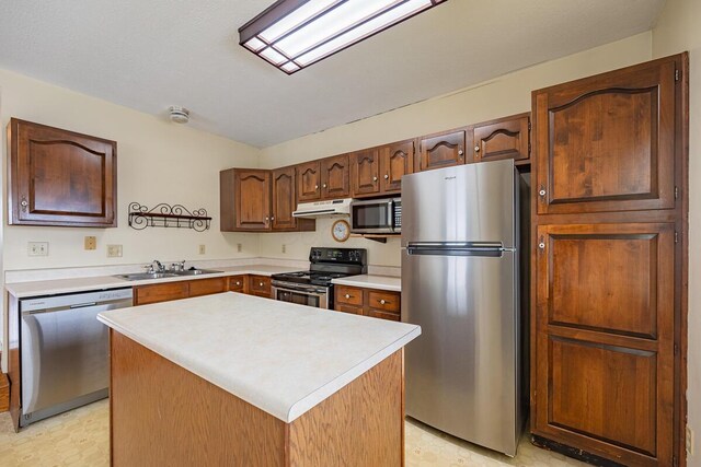 kitchen with stainless steel appliances, a kitchen island, and sink