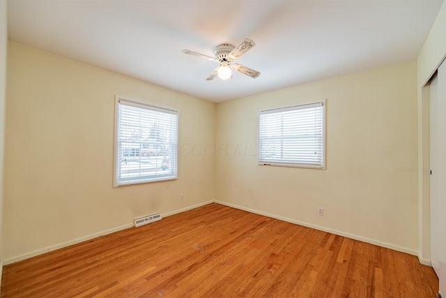 spare room with light hardwood / wood-style floors, ceiling fan, and a healthy amount of sunlight