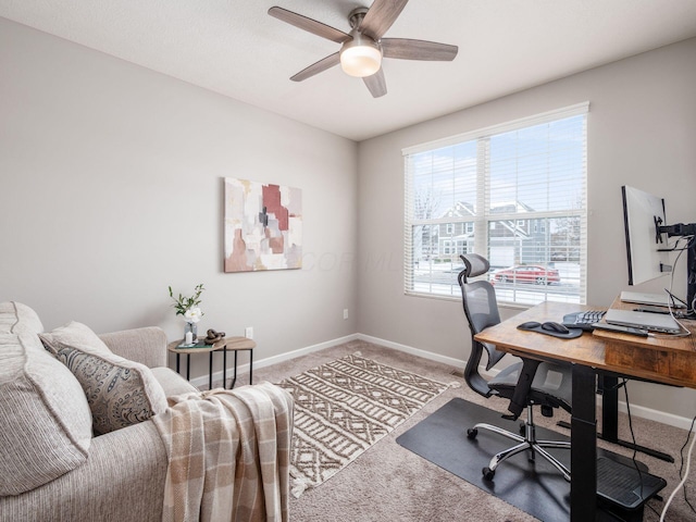 carpeted home office featuring ceiling fan