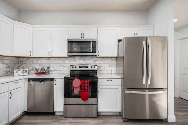 kitchen featuring white cabinetry, appliances with stainless steel finishes, dark hardwood / wood-style floors, and backsplash