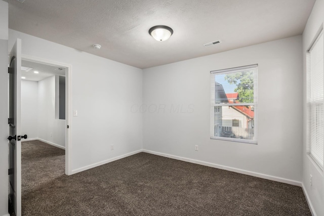 carpeted spare room with a textured ceiling