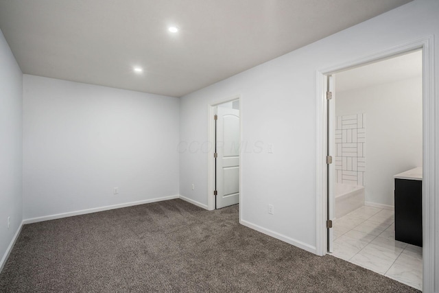 unfurnished bedroom featuring connected bathroom and light carpet